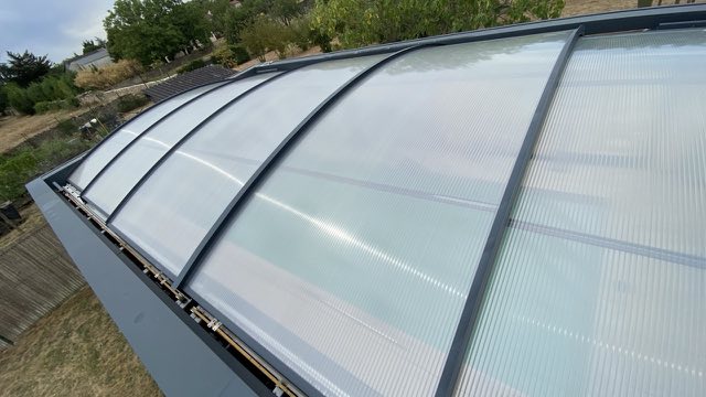 Abri de piscine bombé à panneaux translucides après nettoyage, vu de côté