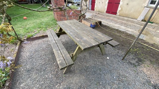 Table de pique-nique en bois grisé et verdi avant nettoyage